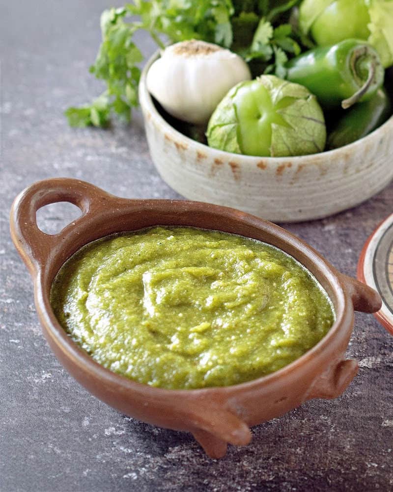 salsa verde in clay pig bowl with veggies in another bowl