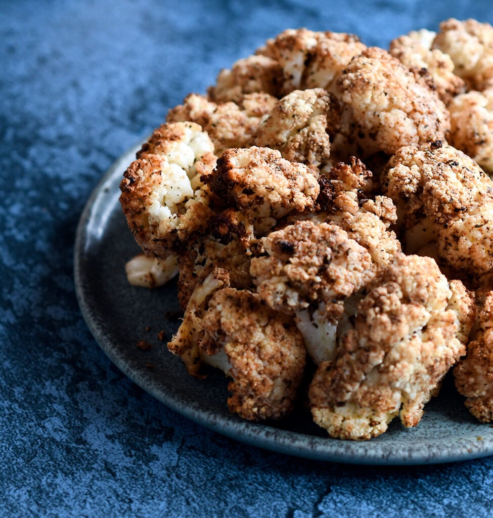 Air Fried Andouille Cauliflower on a blue ceramic plate