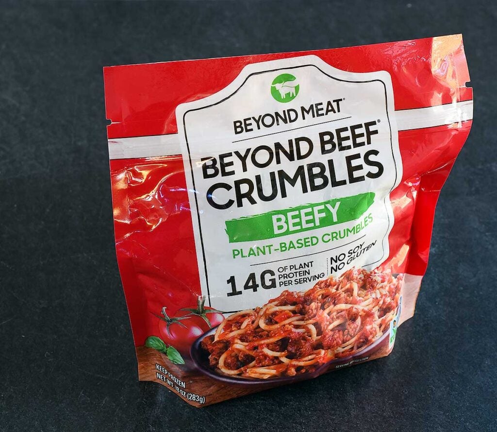 A bag of Beyond Beef Crumbles vegan beef substitute on a grey background.