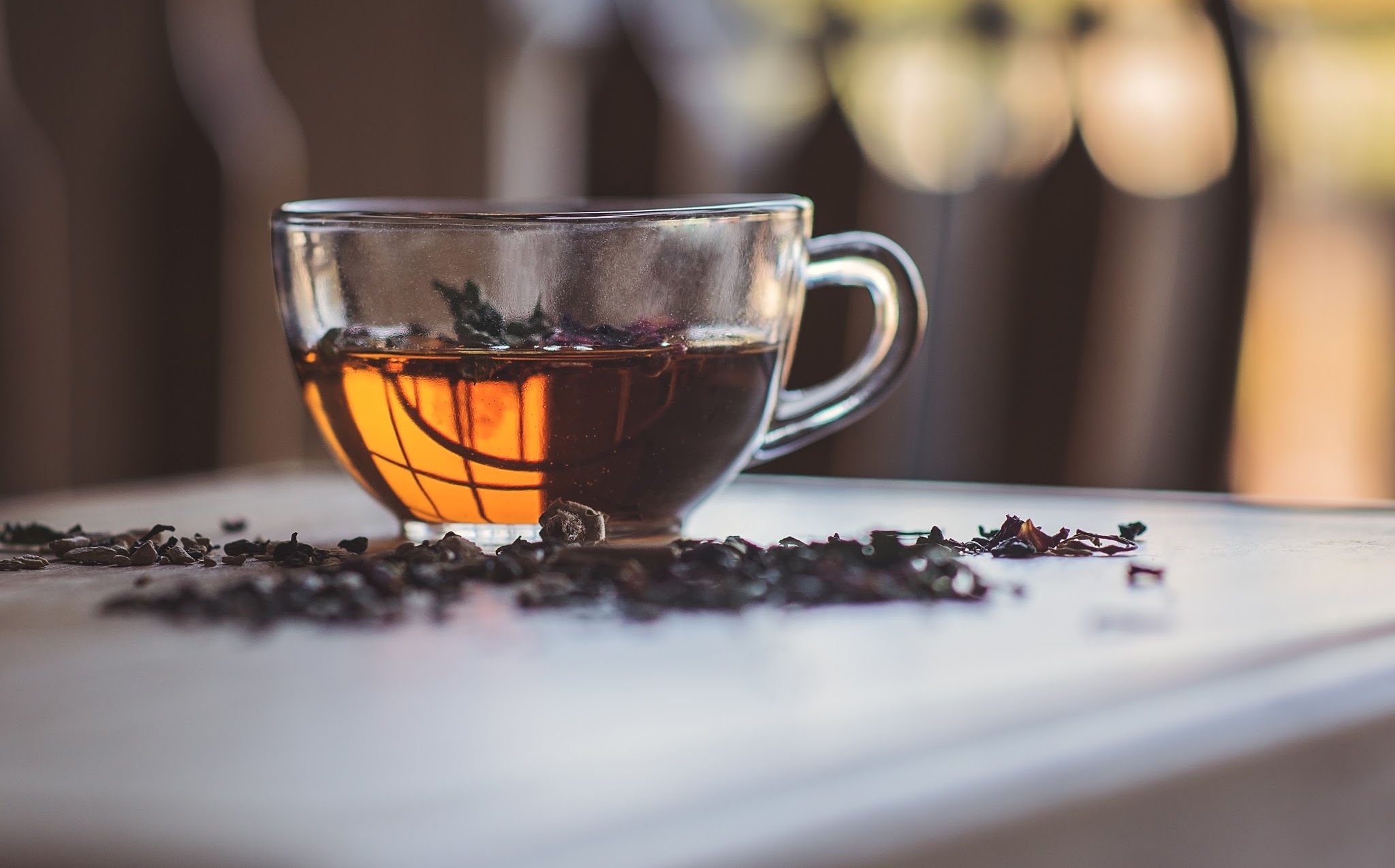 Earl Grey tea on top of a white table with some scattered dried black leaves