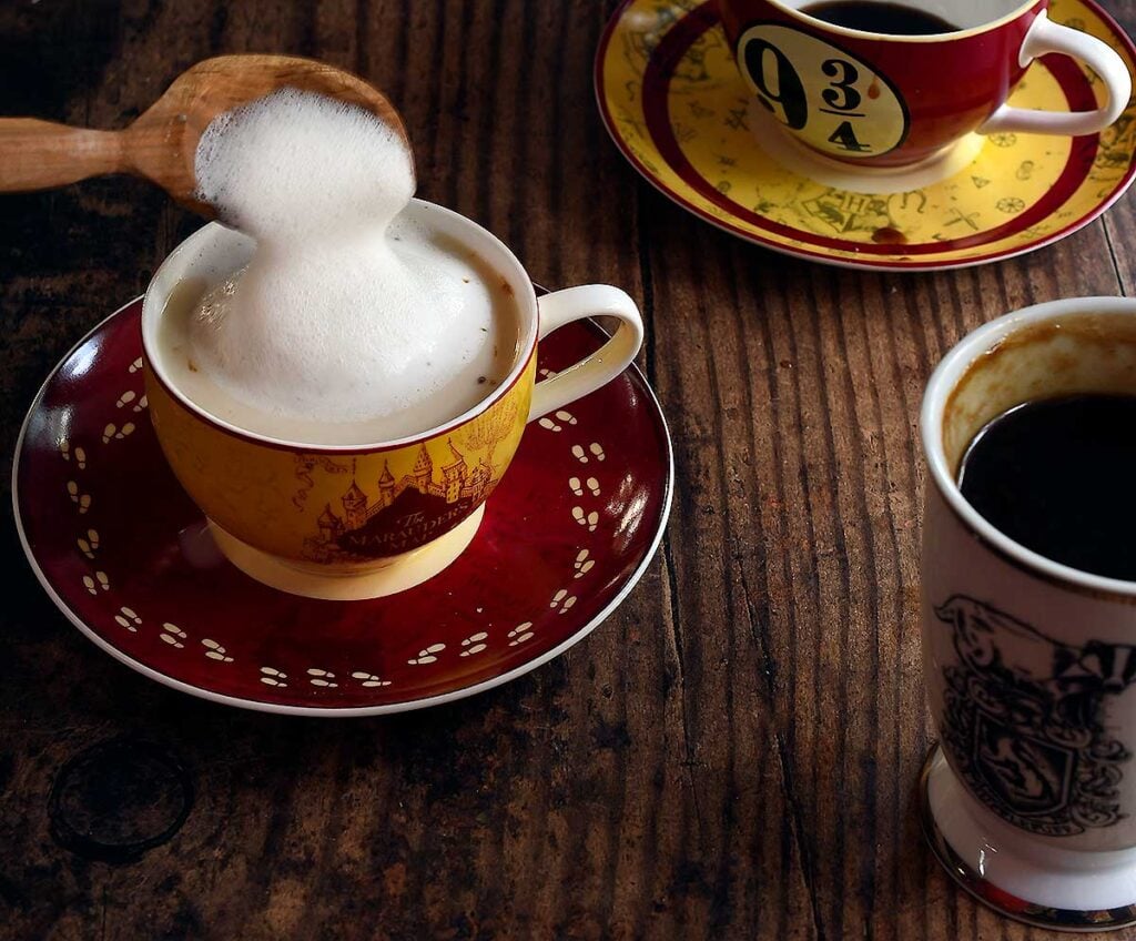Butterbeer with foamed milk topping being spooned on 