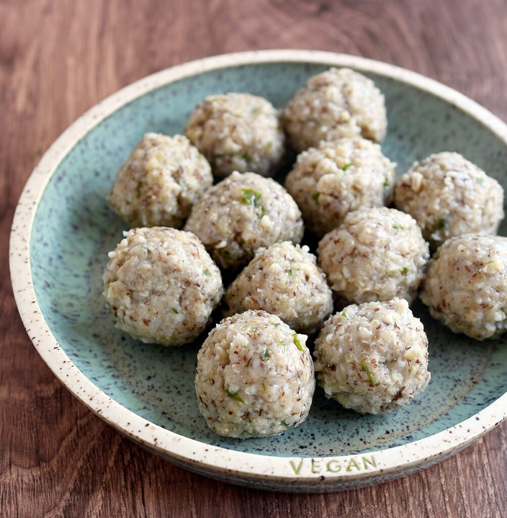 Cooked oat matzo balls on a blue pottery plate.