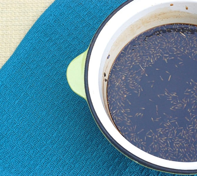 Freshly stirred lavender syrup with buds in a white saucepan