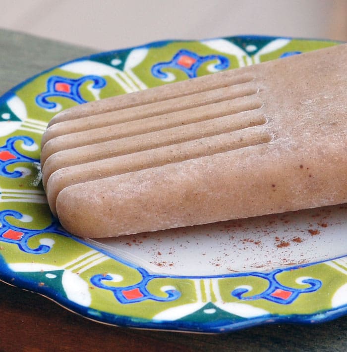close up shot of a vegan chai-spiced banana popsicle on a plate
