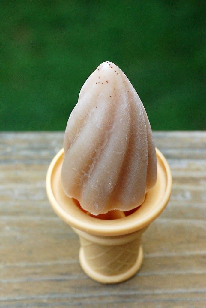 vegan lavender london fog popsicle sitting on a wooden table with green background