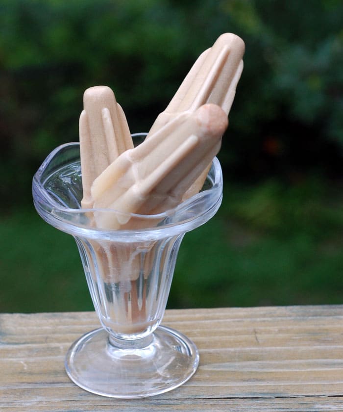 A coupe glass of three delicious Vegan Vanilla Latte Rocket Pops on a wooden table