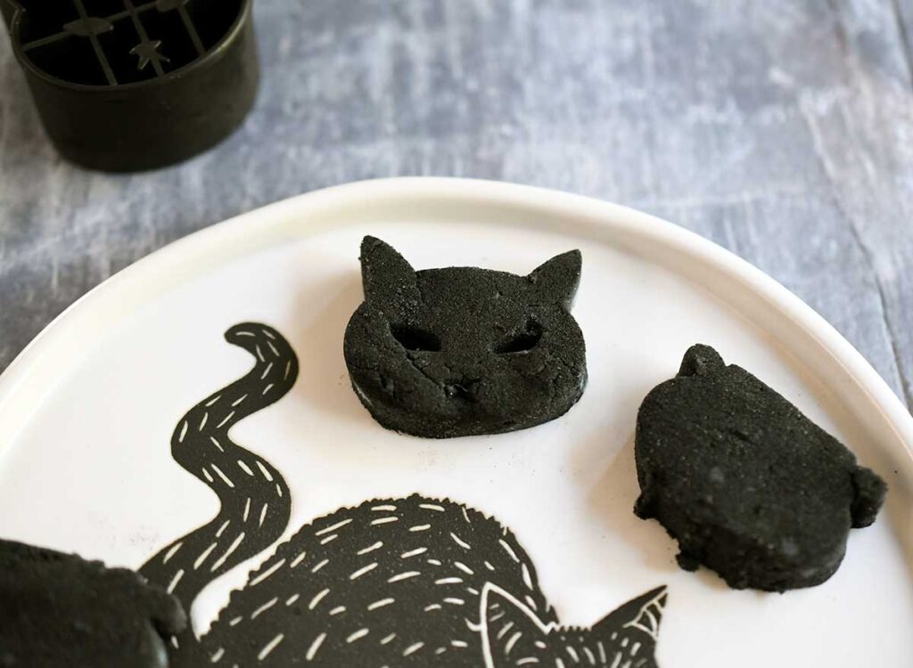 Cat and Cauldron black vegan gnocchi on a Halloween black cat plate.