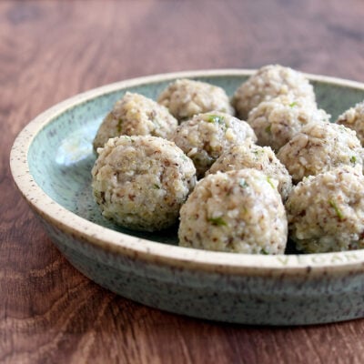 Cooked oat matzo balls on a handmade light blue pottery plate