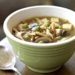 Vegan hot and sour soup with tofu in a green bowl