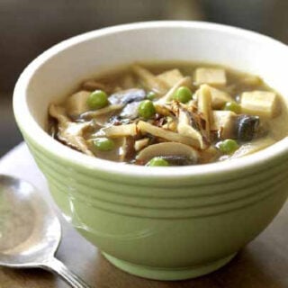 Vegan hot and sour soup with tofu in a green bowl