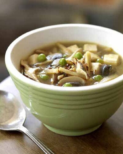 Vegan hot and sour soup with tofu in a green bowl