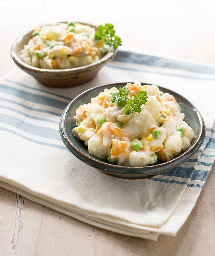 2 Potato Salad in small bowls on white cloth with blue stripes