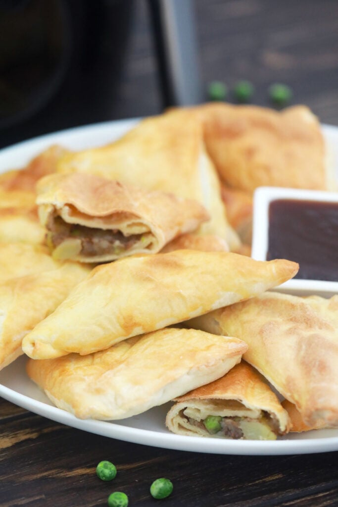 45 degree angle shot of a platter of crispy vegan air fryer samosas.