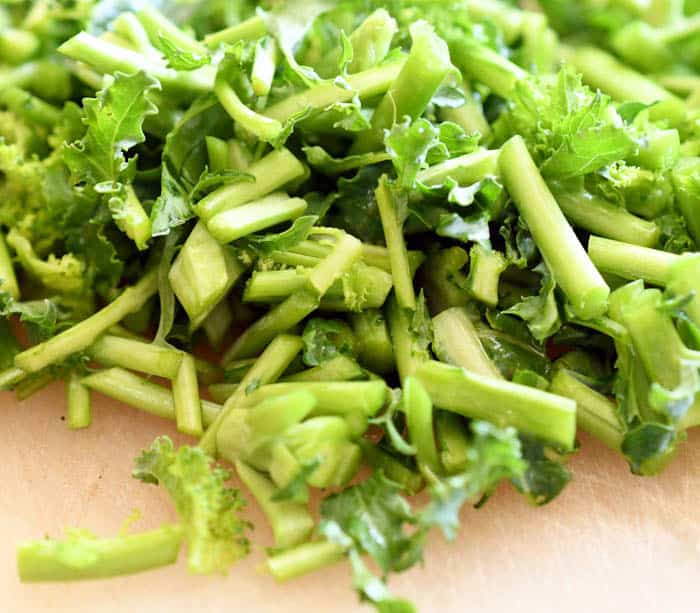 Leftover kale stems chopped on top of cooking board