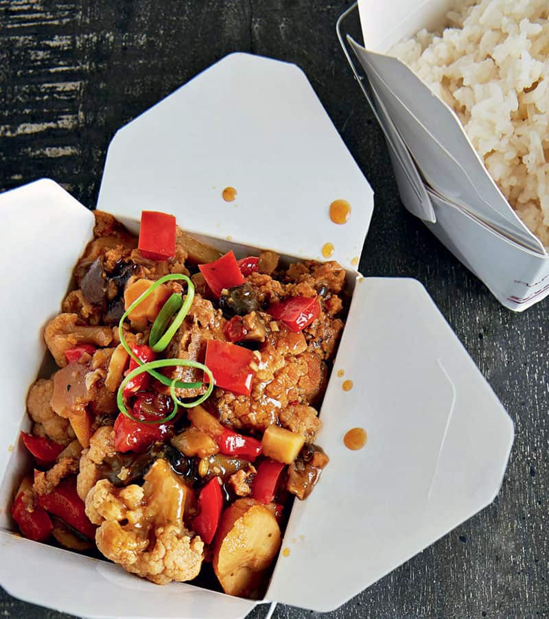 Slow Cooker Kung Pao Cauliflower on a disposable paper box packaging with a rice box on the side