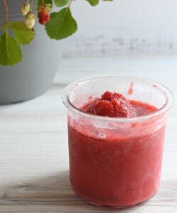 Strawberry ice cream in a Ninja Creami pint with a hump.