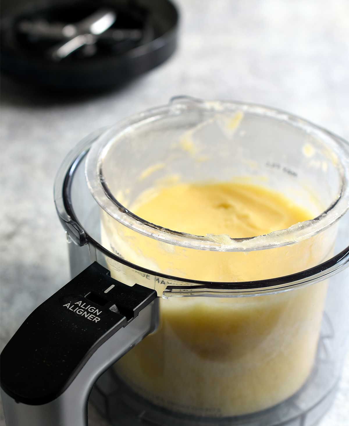 Pineapple whip in a Ninja Creami pint in its outer bowl.