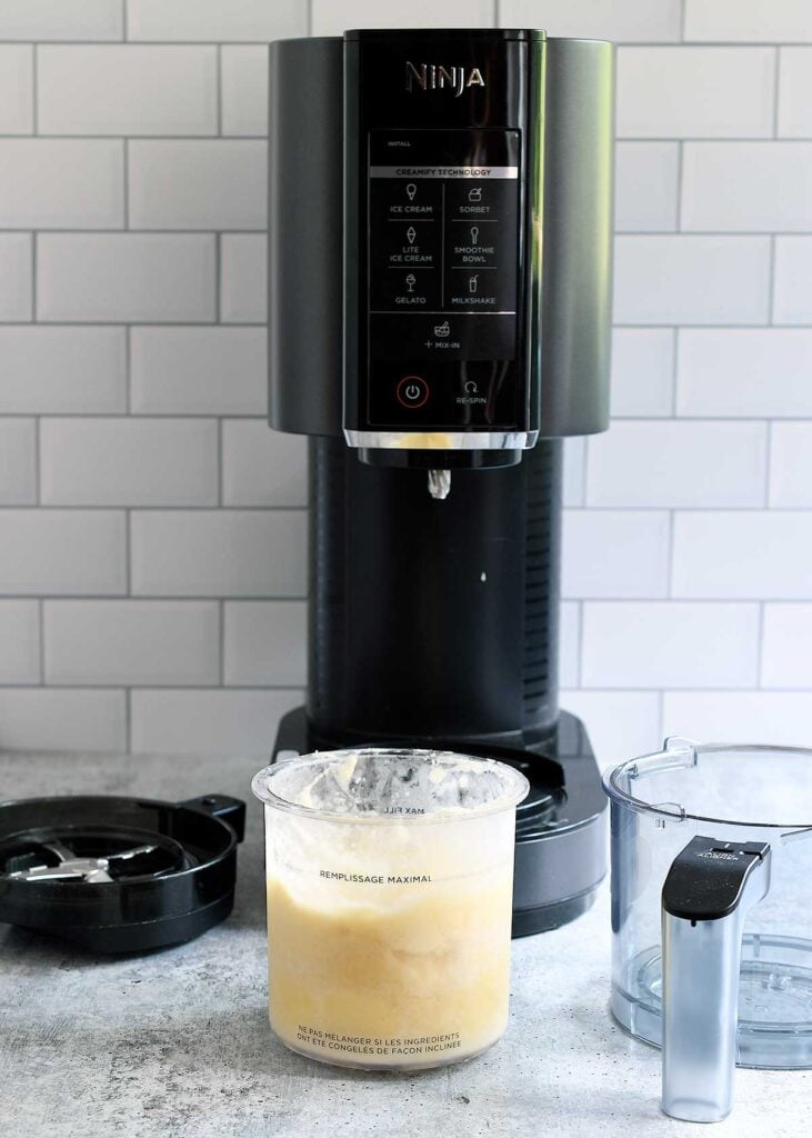 Ninja Creami with a pint of pineapple sorbet ready to spin.