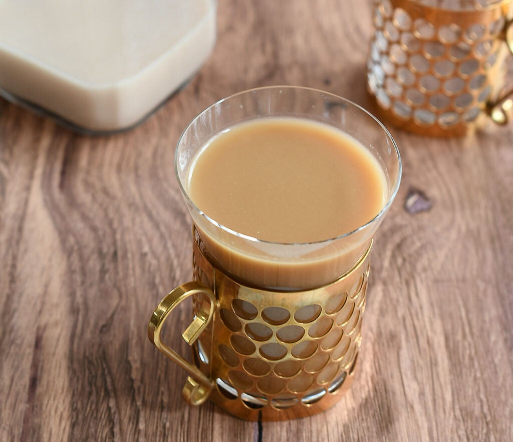Maple pecan coffee in a glass and gold coffee cup.