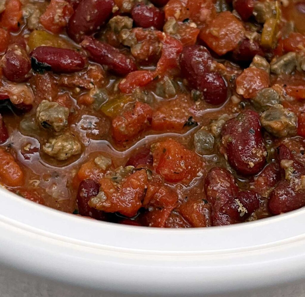 Slow cooker chili in a small white slow cooker.