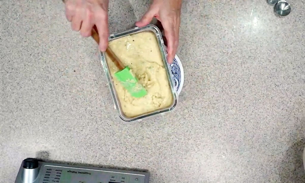 Smoothing out cooked cheese mixture in a mold