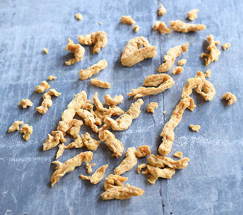 Scattered soy curls on a grey wooden table.