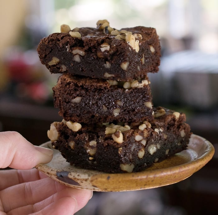 Gluten Free Vegan Teff Brownies stacked up on a brown pottery plate