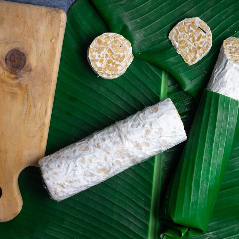 round tempeh on banana leaves