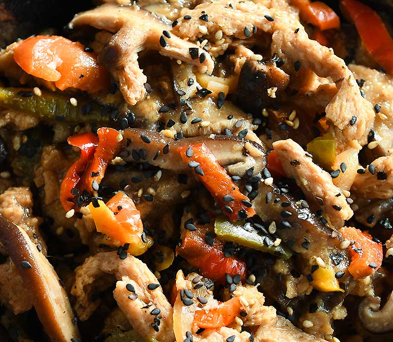 Date Sweetened Teriyaki Soy Curls in a brown ceramic bowl with bell peppers and mushrooms