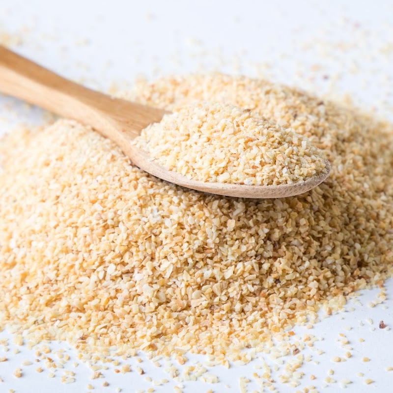 granulated garlic in wooden teaspoon