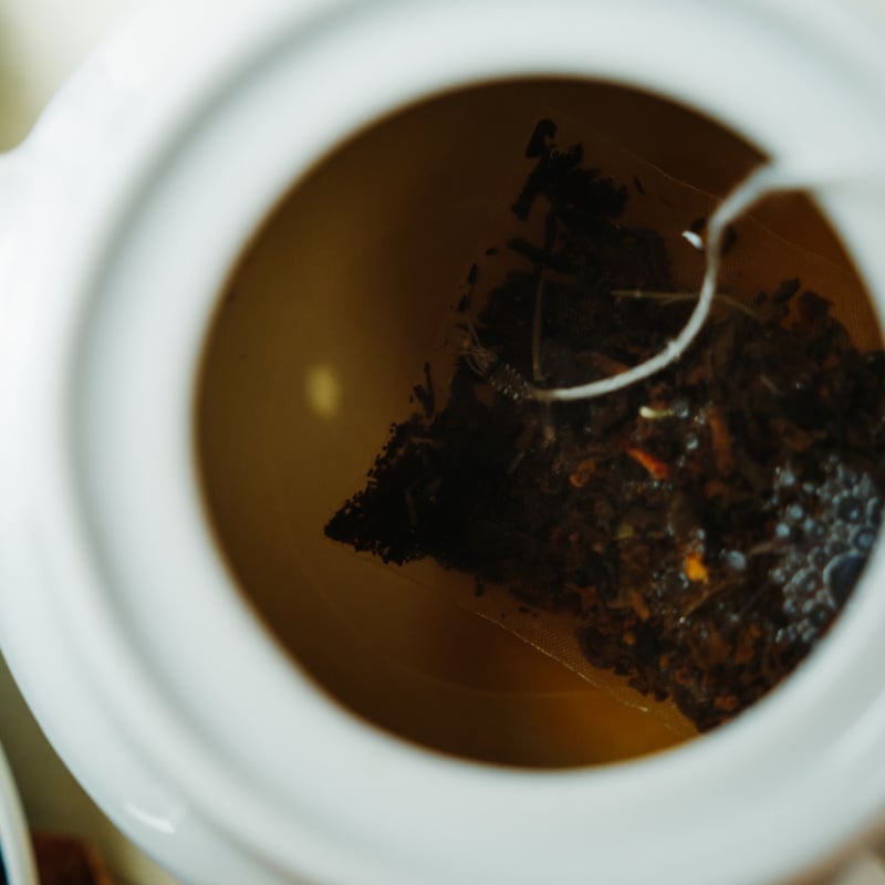 Earl Grey tea in white tea cup with tea bag still seeping