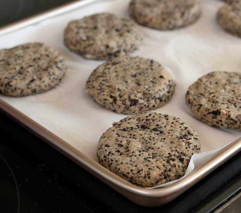 Vegan Sausage Patties on parchment paper and baking sheet ready to go into the oven